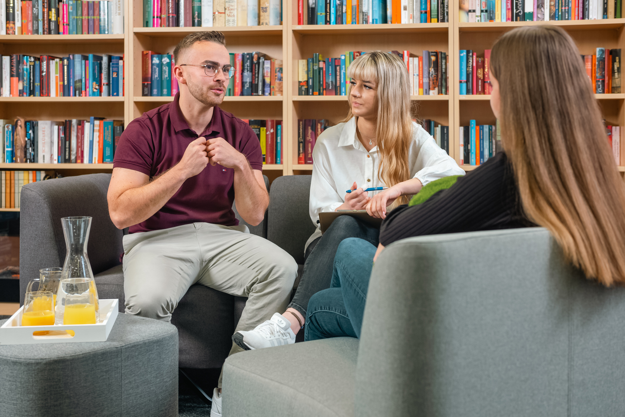 Schüler sprechen auf dem Schulhof mit Sozialarbeiterin