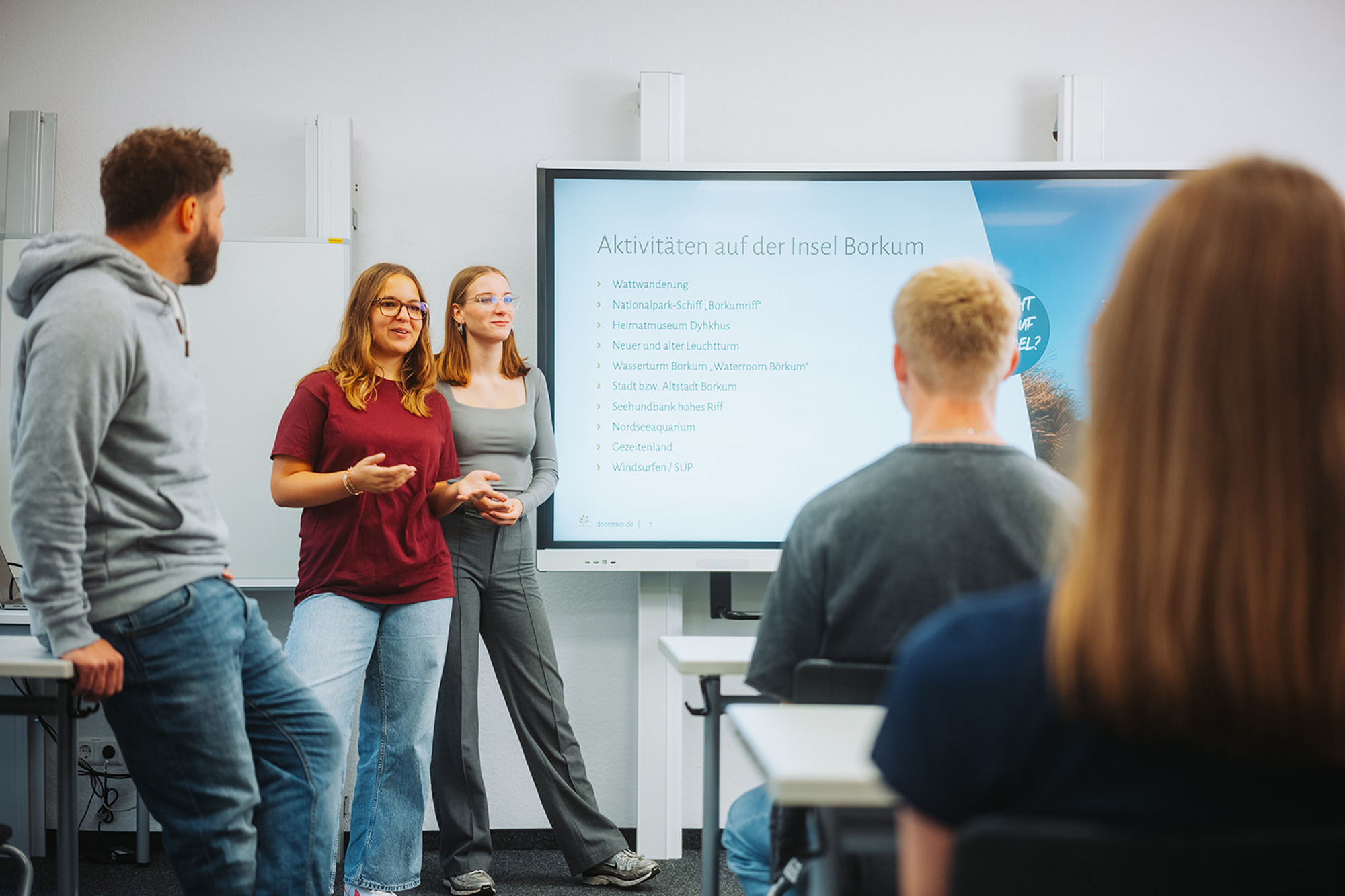 Lehrer und Schülerin im Gespräch am digitalen Smartboard