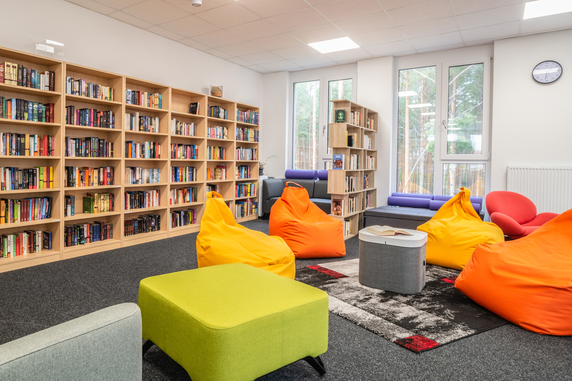 Einblick in die mit vielen Büchern gefüllte Mediathek in Neu Zittau, Sitzgelegenheiten laden zum Verweilen ein 